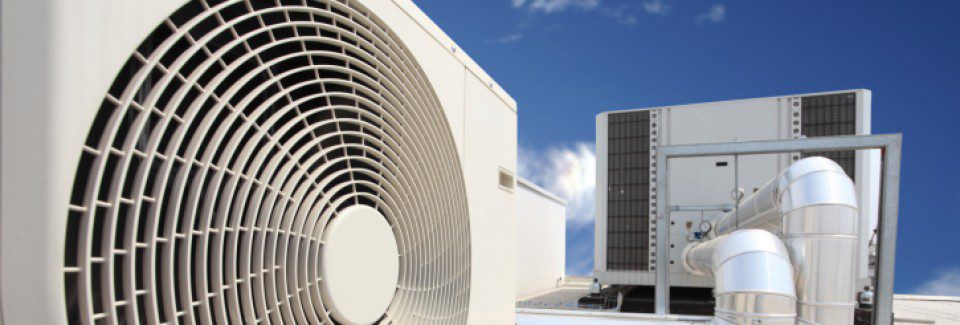 A large white air conditioner on top of a building.