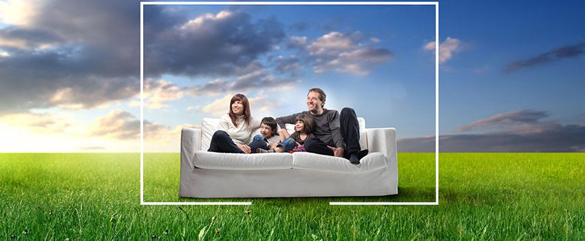 A family sitting on the couch in front of a sky background