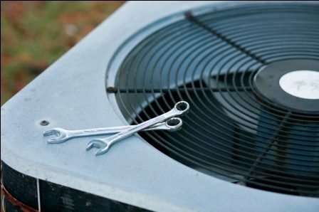 A pair of scissors sitting on top of an air conditioner.