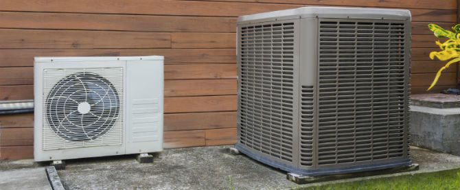 A large air conditioner sitting next to a building.