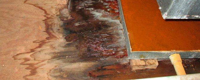 A rotten floor with red paint and water
