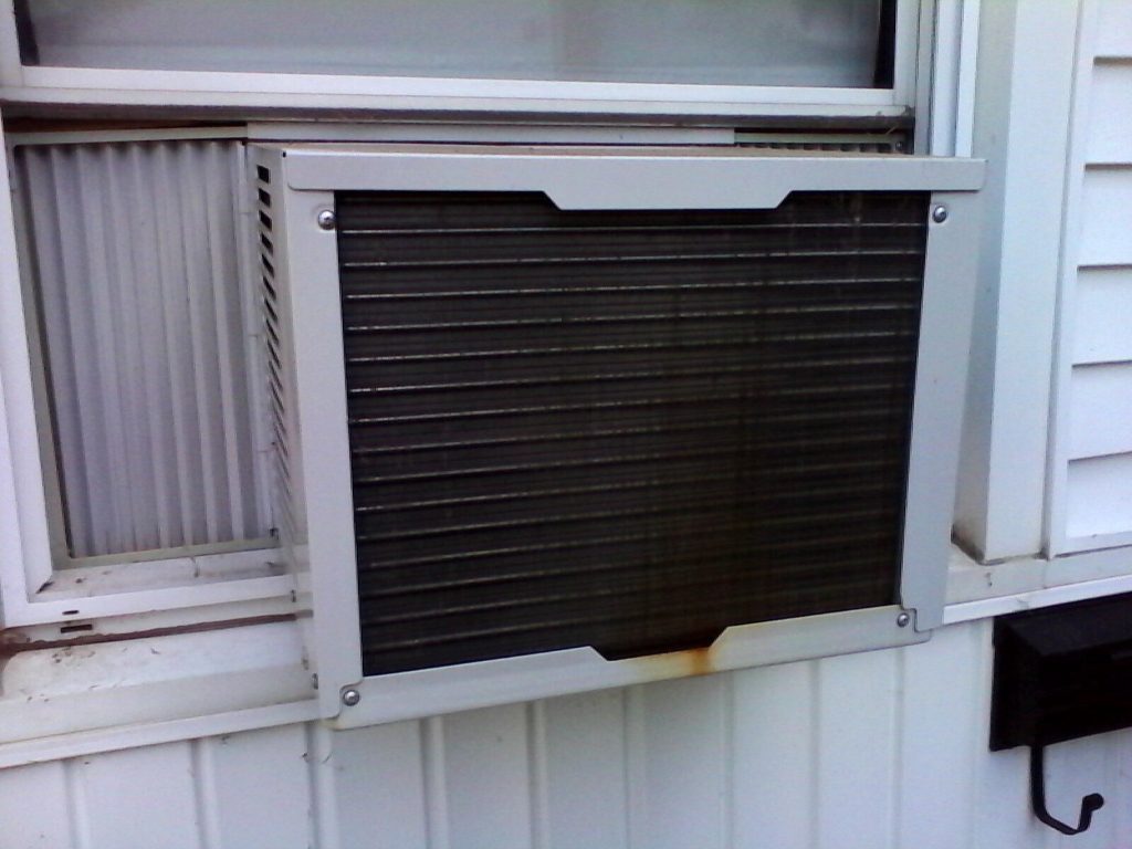 A window air conditioner is closed and dirty.